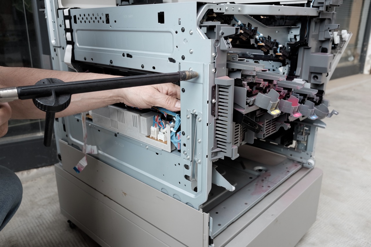 technician repairs photocopier