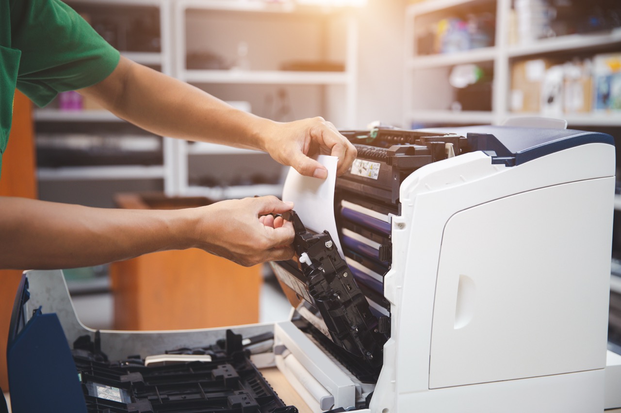 Technician hand open cover photocopier or photocopy to fix repair copier paper jam and replace ink cartridges for scanning fax or copy document in office workplace.